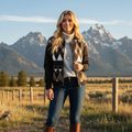 Blonde woman in geometric bomber with dark jeans in Canadian landscape