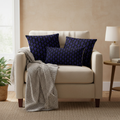 Luxurious cozy living room with deep blue and black geometric pillows on cream beige armchair