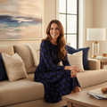 Radiant positive woman in deep blue and black long sleeve midi dress in luxurious cozy living room
