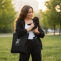 Woman holding black pug puppy with eco tote bag in urban park