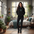 Woman in black Adventure Freedom Travel hoodie in modern bedroom