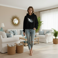 Woman in cropped Night Wing hoodie in coastal living room